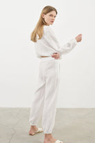 Siena Top displayed on a hanger, showcasing its wide sleeves and the unique V-shaped front drape with a hidden optional closure.