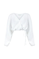 Siena Top displayed on a hanger, showcasing its wide sleeves and the unique V-shaped front drape with a hidden optional closure.