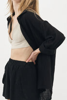 A woman wearing the Sundown Top, showcasing its relaxed fit, short sleeves, and flattering neckline, a versatile and stylish option for any occasion.