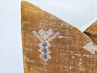 Image of the 'Moroccan Rug Design Embroidered Pillow Cover', highlighting the hand-embroidered motifs, the hand-painted color, and the handmade cotton yarn tassels.