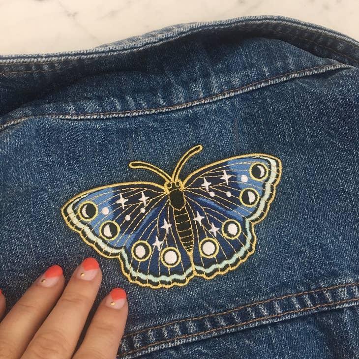 Large embroidered patch showcasing a butterfly in deep navy hues with twinkling star accents.