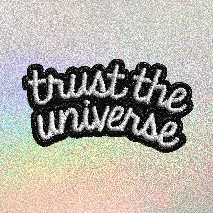 Elegant embroidered patch with the text "Trust the Universe".