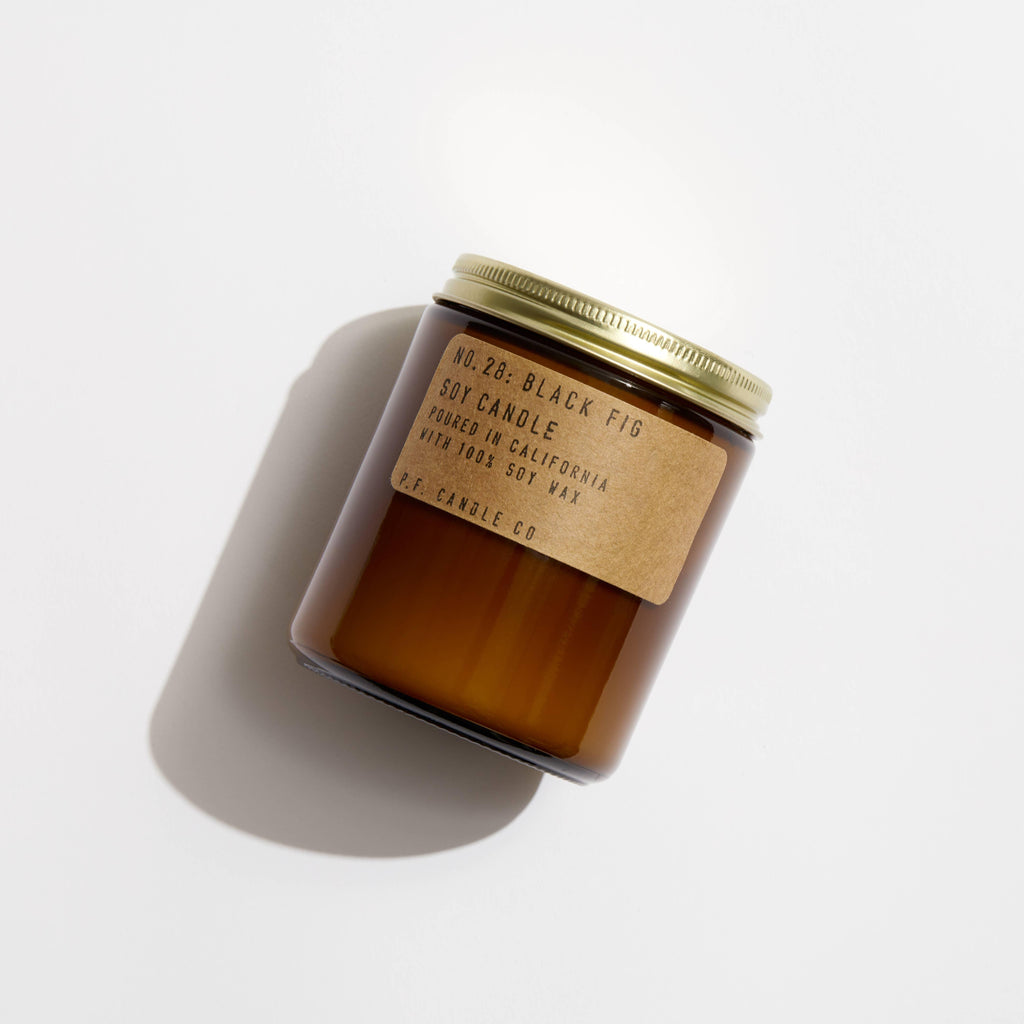 Elegant Black Fig Soy Candle in a glass container, flickering with a warm and soothing glow.