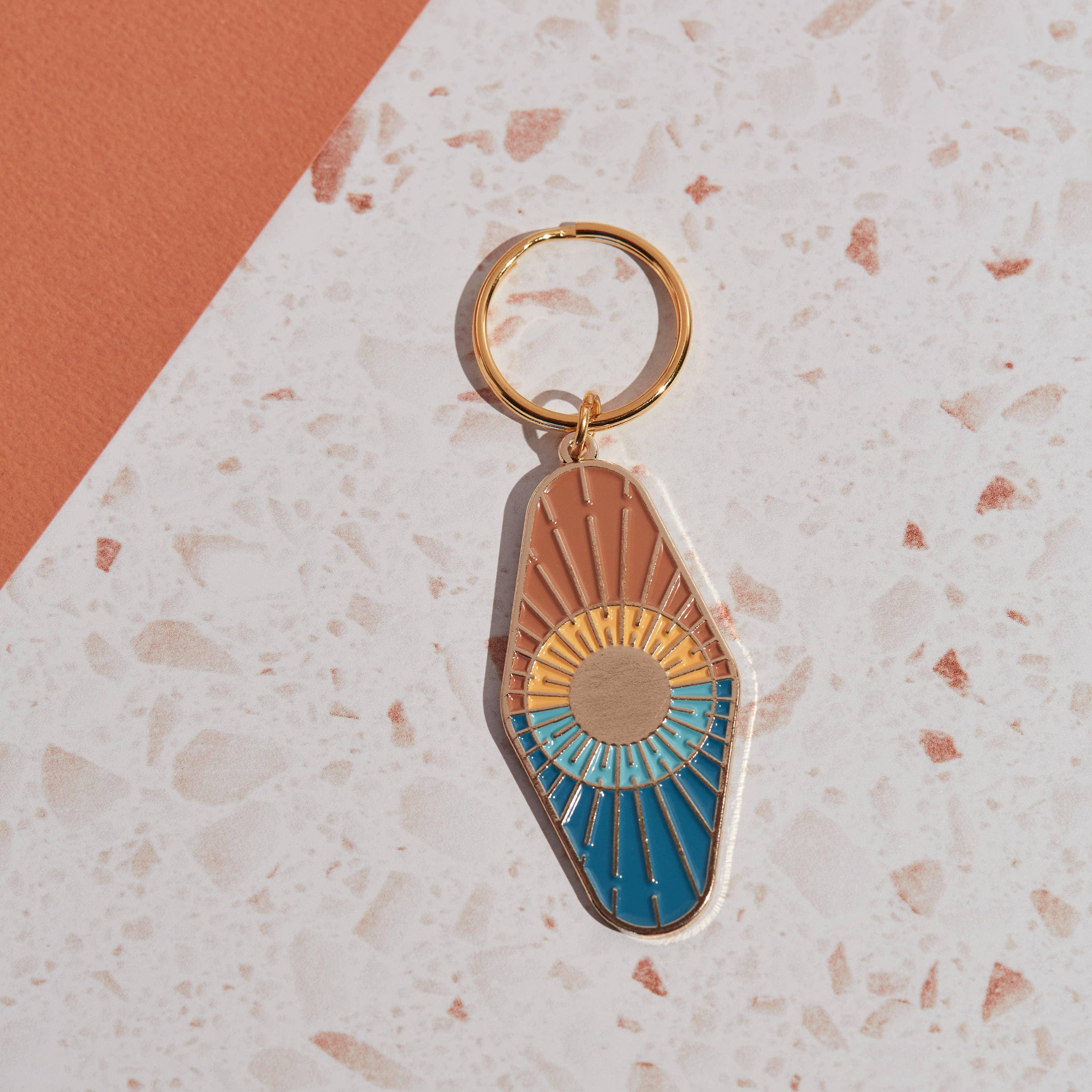 'Sun and Sea Enamel Keychain' made from sturdy enamel, featuring a fun sun-and-sea design"