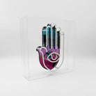 Yellow, pink, and white Neon Hamsa Hand Light encased in a glossy acrylic box with printed graphics by FORMA.