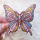 Embroidered patch of a luminous butterfly with intricate, mystical designs.