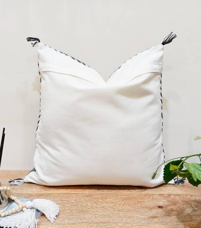 Image showcasing the 'Blue Embroidered Pillow Cover', meticulously crafted from 100% organic cotton and natural fibers, highlighting its intriguing design.