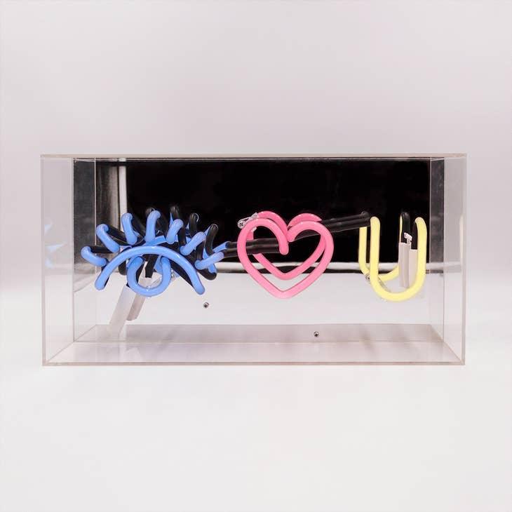 FORMA's Neon "Eye Love You" Lights in blue, red, and yellow, illuminating an affectionate message in a stylish way.