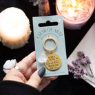 Clear quartz crystal keychain with gold-tone pendant and inspirational message on display card.