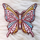 Embroidered patch of a luminous butterfly with intricate, mystical designs.