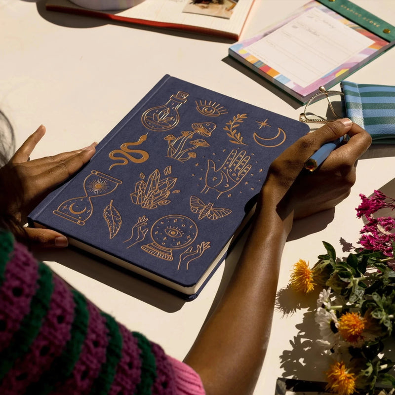 Image showcasing the 'Mystic Icons Cloth Covered Journal', featuring an enchanting cover adorned with mystical symbols.