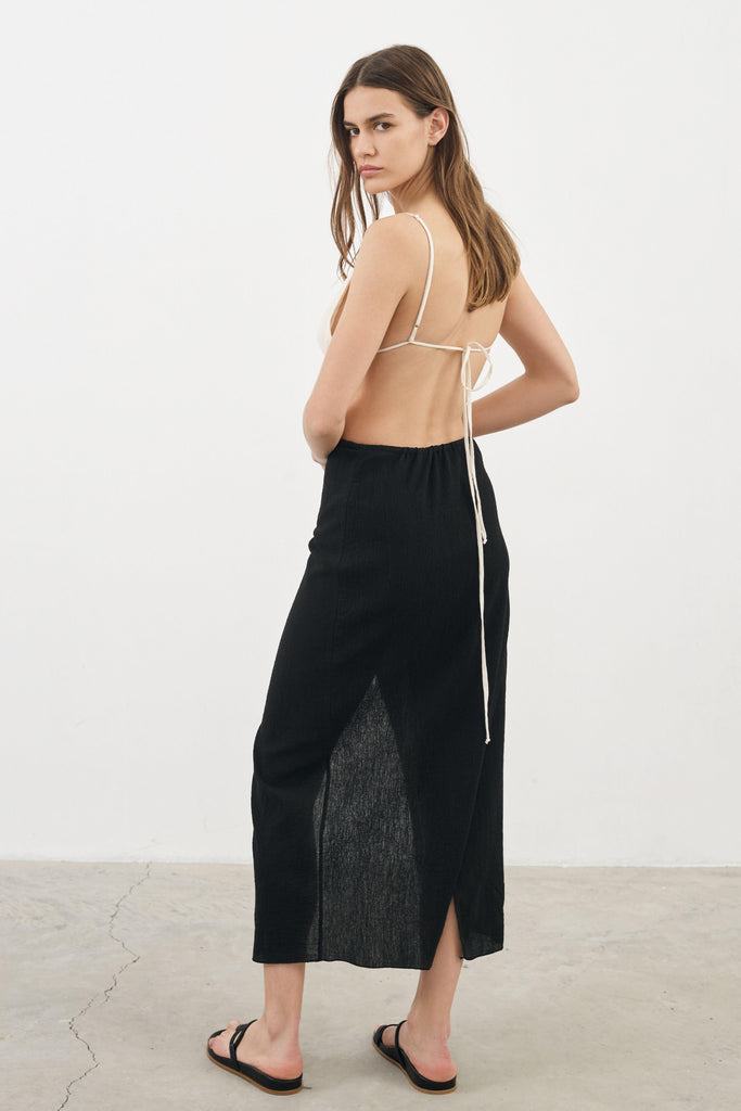 A woman wearing the Sia Skirt, showcasing its flattering A-line silhouette, elastic waistband, and versatile design, a stylish and comfortable choice.