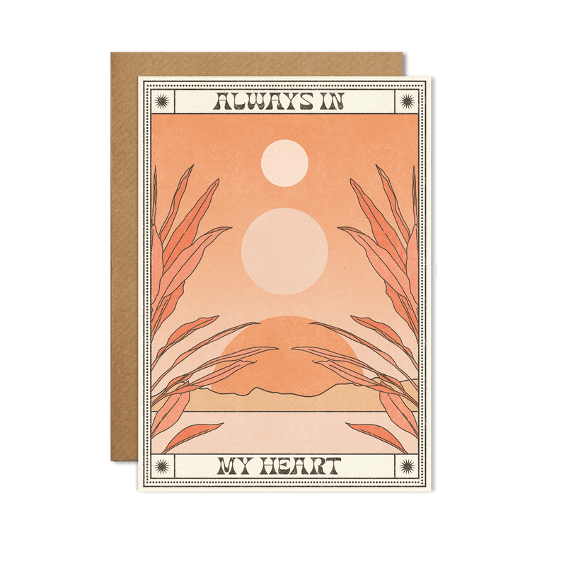 Close-up image of an "Always In My Heart" Card with elegant design elements, placed on a warm wooden background.