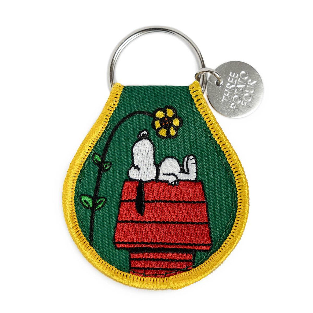Peanuts Snoopy Doghouse Flower Patch Keychain - A whimsical keychain adorned with Snoopy's doghouse and blooming flowers for added charm.