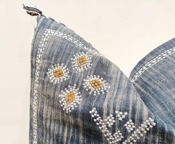 Image showcasing the 'Blue Embroidered Pillow Cover', meticulously crafted from 100% organic cotton and natural fibers, highlighting its intriguing design.