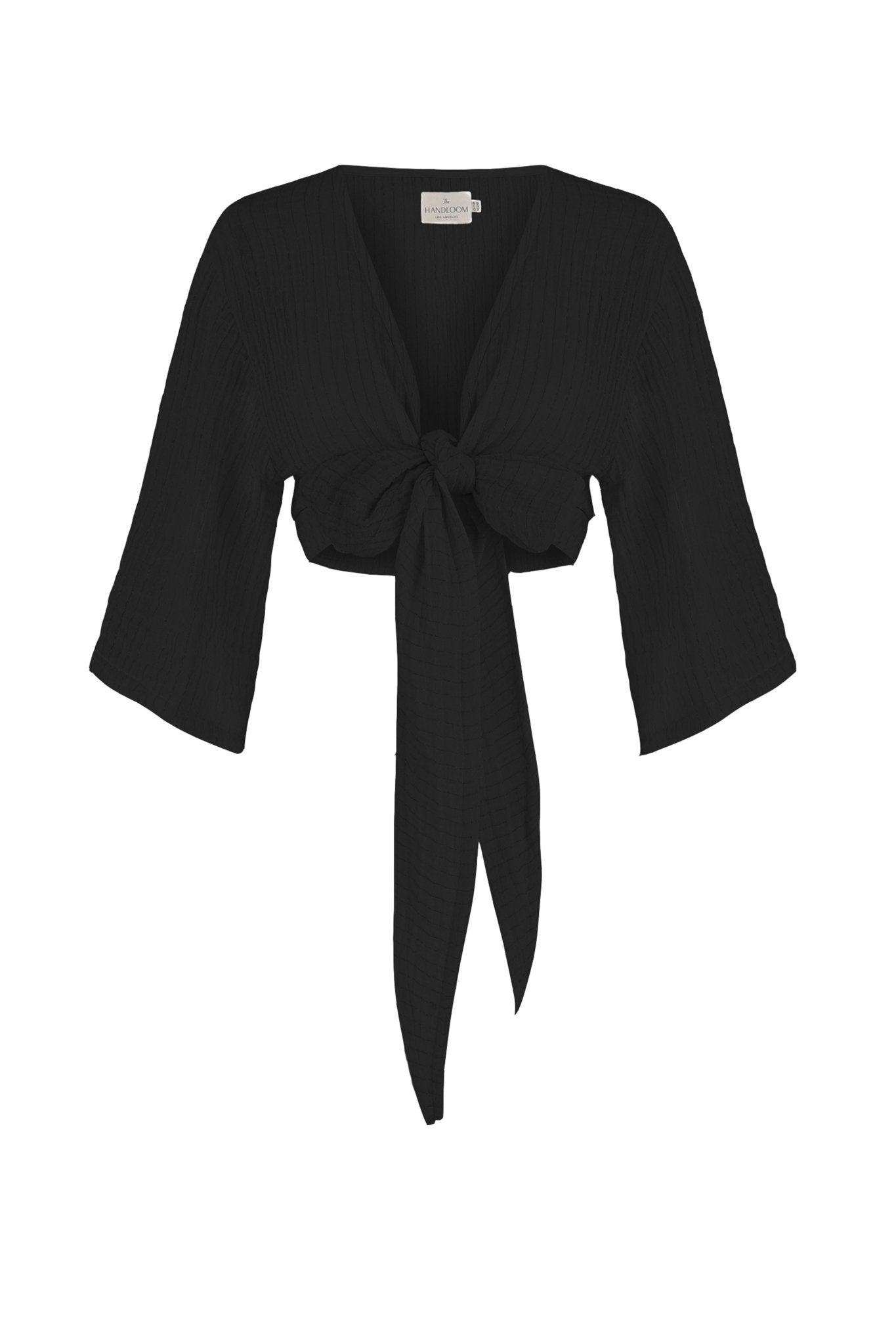 Stylish woman posing in a Bali Wrap Top with a V-neckline, front tie closure, and wide sleeves, highlighting its Turkish cotton fabric.