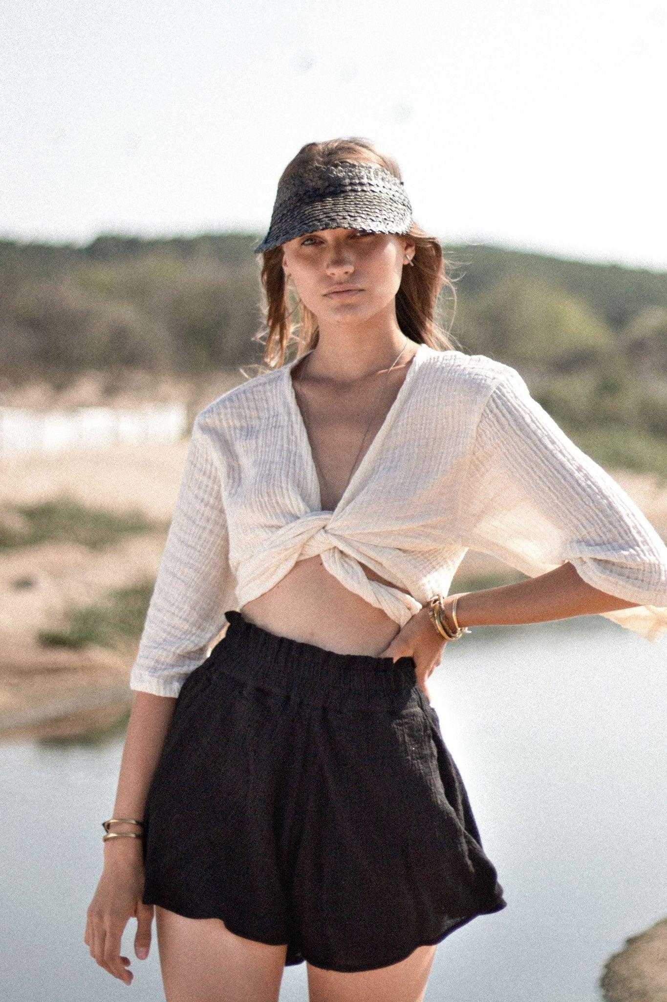 Stylish woman posing in a Bali Wrap Top with a V-neckline, front tie closure, and wide sleeves, highlighting its Turkish cotton fabric.