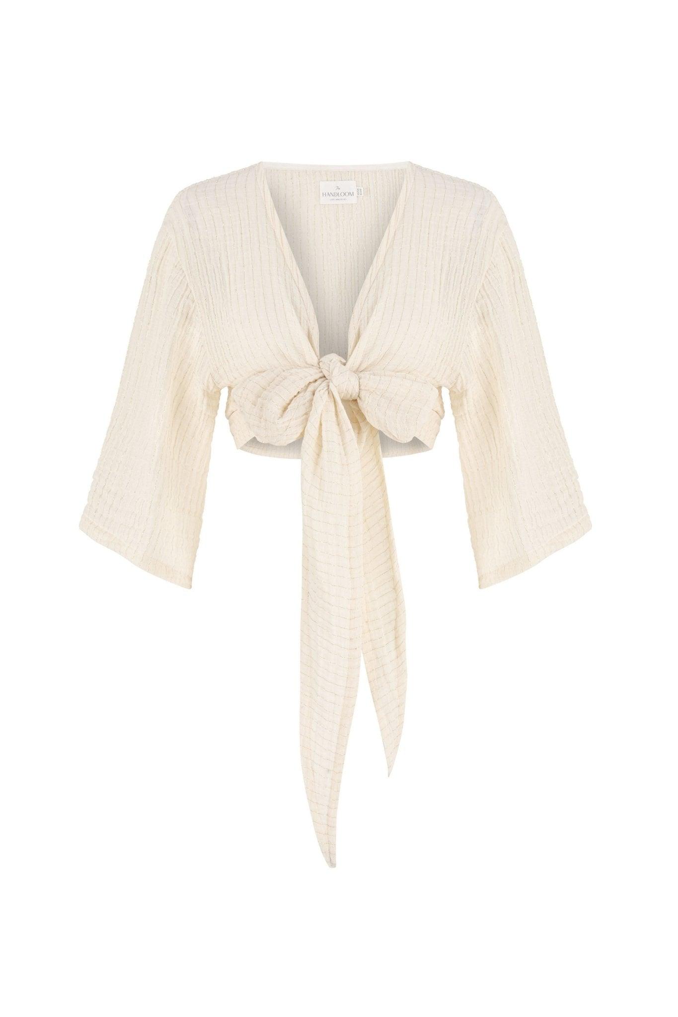Stylish woman posing in a Bali Wrap Top with a V-neckline, front tie closure, and wide sleeves, highlighting its Turkish cotton fabric.