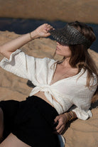 Stylish woman posing in a Bali Wrap Top with a V-neckline, front tie closure, and wide sleeves, highlighting its Turkish cotton fabric.