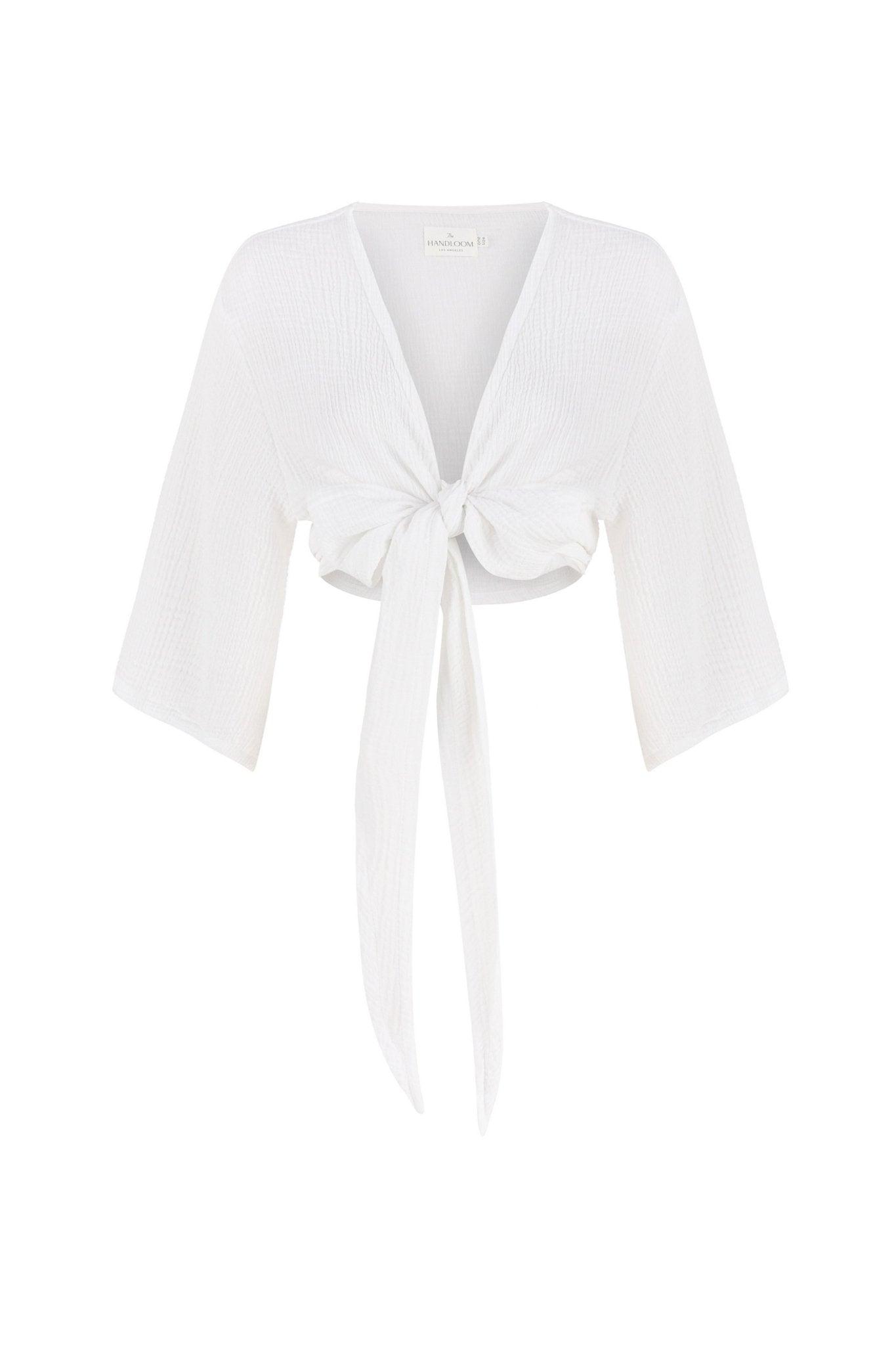 Stylish woman posing in a Bali Wrap Top with a V-neckline, front tie closure, and wide sleeves, highlighting its Turkish cotton fabric.