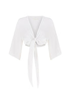 Stylish woman posing in a Bali Wrap Top with a V-neckline, front tie closure, and wide sleeves, highlighting its Turkish cotton fabric.