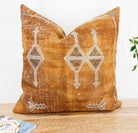 Image of the 'Moroccan Rug Design Embroidered Pillow Cover', highlighting the hand-embroidered motifs, the hand-painted color, and the handmade cotton yarn tassels.