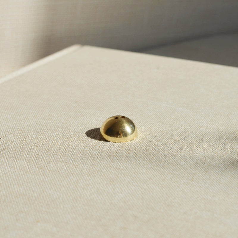 A stylish Brass Arch Incense Holder on a sleek backdrop, exuding modern elegance, designed to hold incense effortlessly.