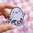 Iridescent glitter ghost patch with cosmic details - planet, moon, and stars, bordered by a shimmering gold trim.