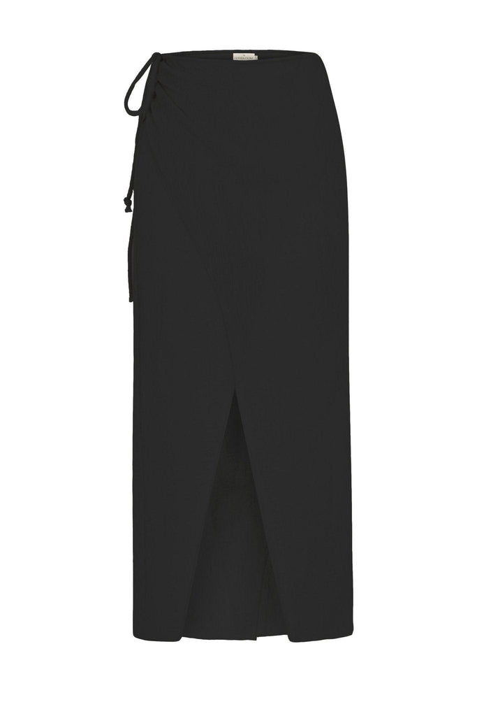 A woman wearing the Sia Skirt, showcasing its flattering A-line silhouette, elastic waistband, and versatile design, a stylish and comfortable choice.