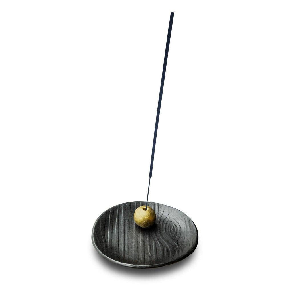 Hand-crafted Black Forest Incense Holder in matte black stoneware, displaying an embossed wood-grain pattern and gold ball for stick positioning.