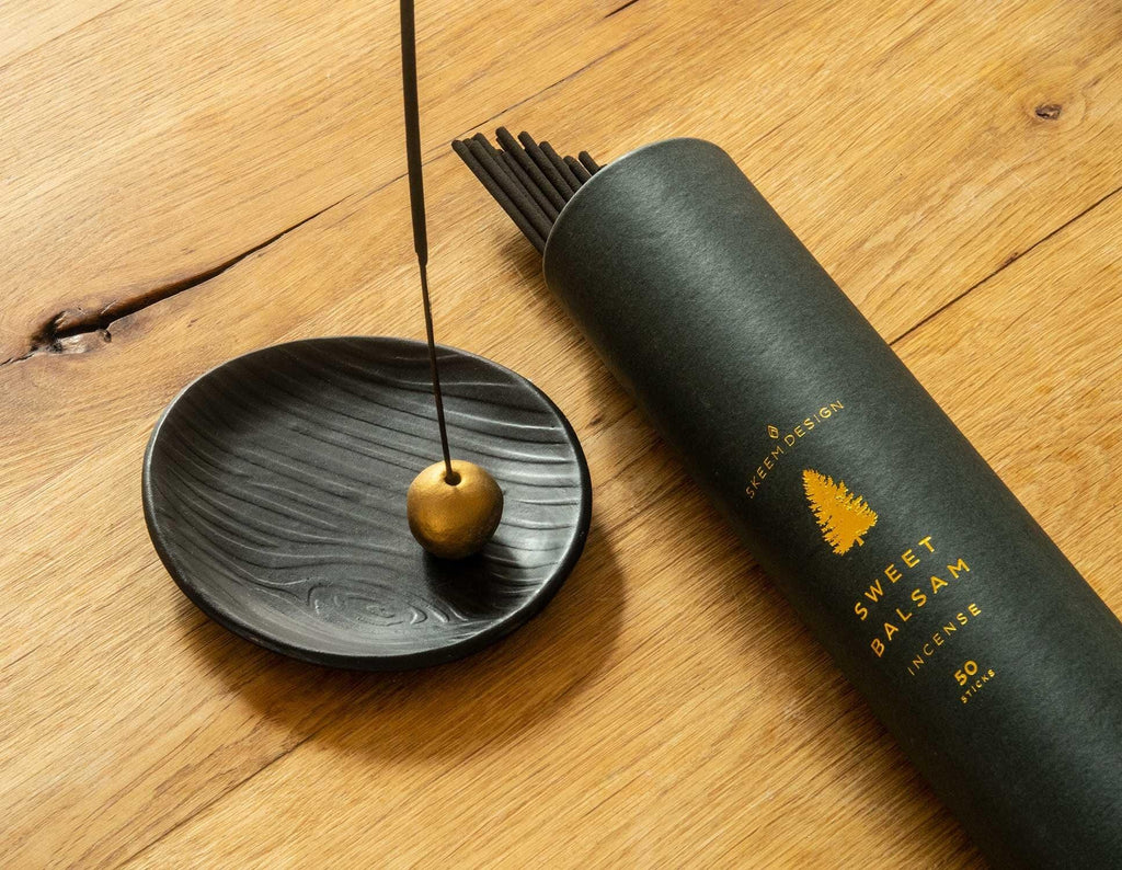 Hand-crafted Black Forest Incense Holder in matte black stoneware, displaying an embossed wood-grain pattern and gold ball for stick positioning.