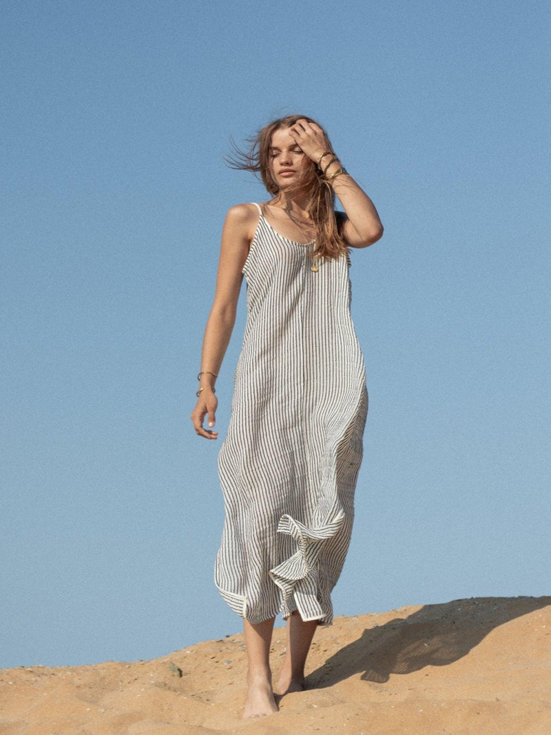 Woman wearing the Yaz Dress, a flowing summer dress with a vibrant print, perfect for sunny days and warm evenings.