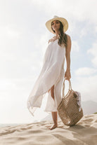 Woman wearing the Yaz Dress, a flowing summer dress with a vibrant print, perfect for sunny days and warm evenings.