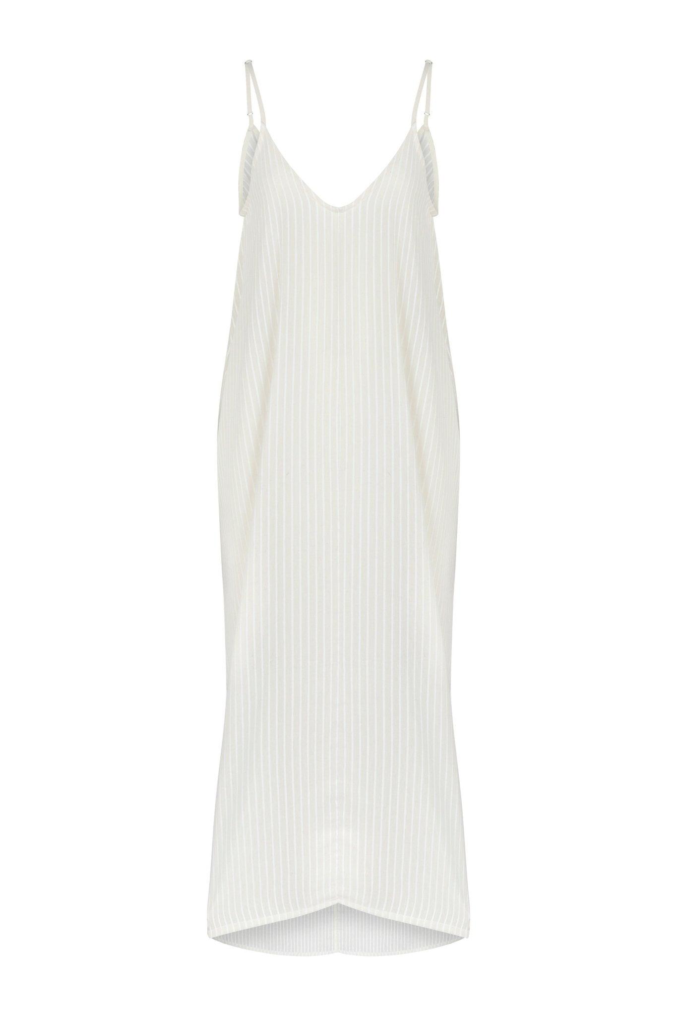Woman wearing the Yaz Dress, a flowing summer dress with a vibrant print, perfect for sunny days and warm evenings.