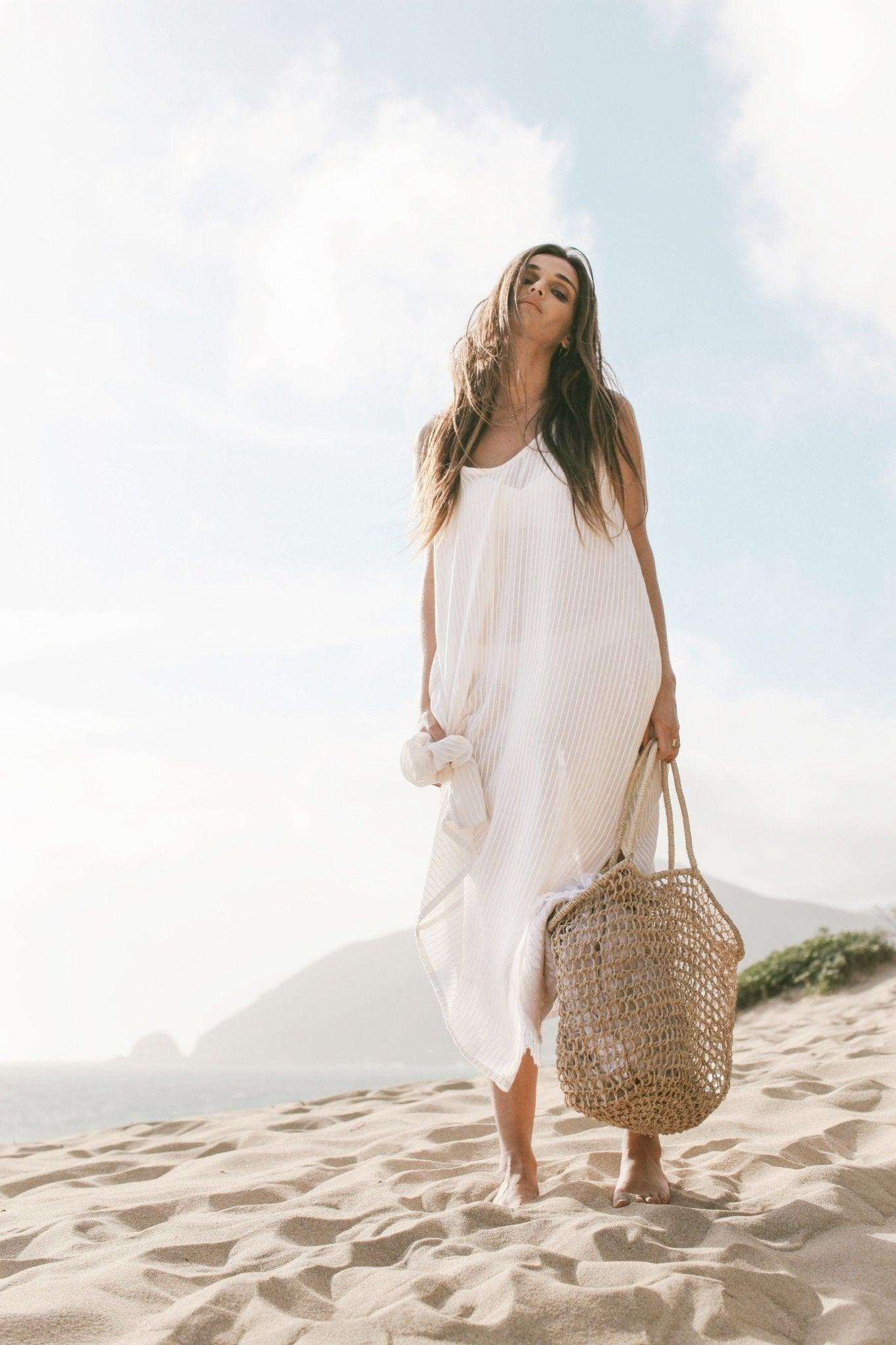 Woman wearing the Yaz Dress, a flowing summer dress with a vibrant print, perfect for sunny days and warm evenings.