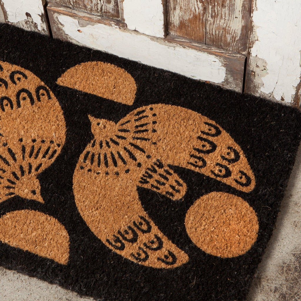 Myth Doormat - Biodegradable coir doormat with soaring dove design against a rustic black backdrop.
